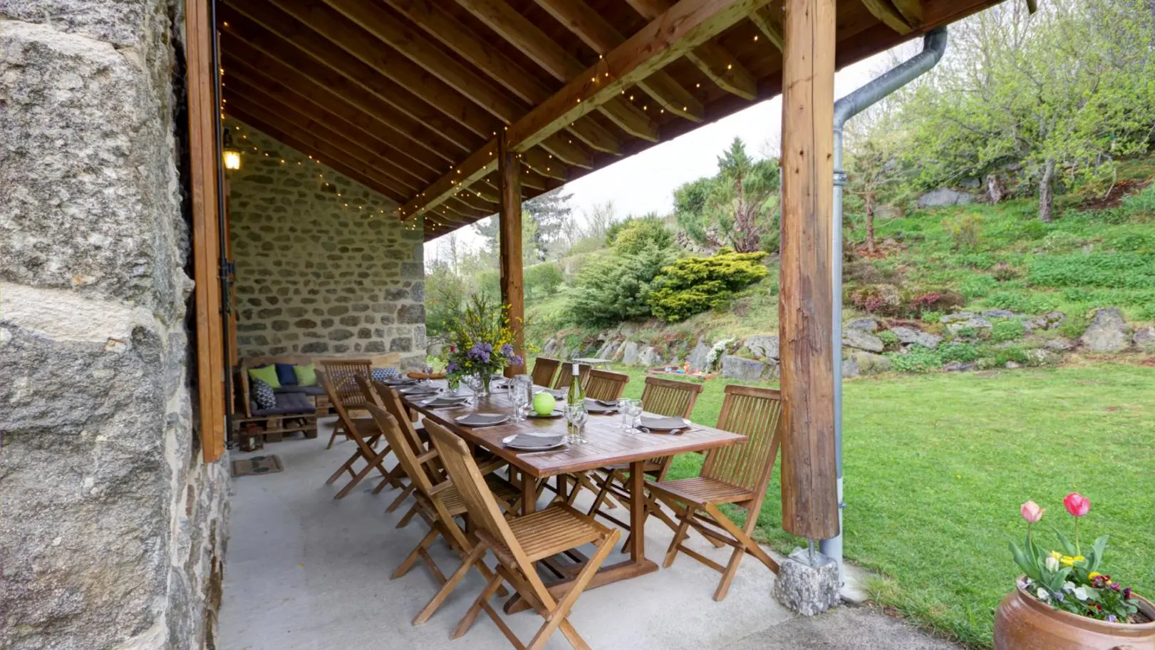 Terrasse couverte avec ses 2 tables et son canapé