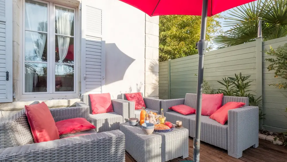 Un salon de jardin sous un parasol.