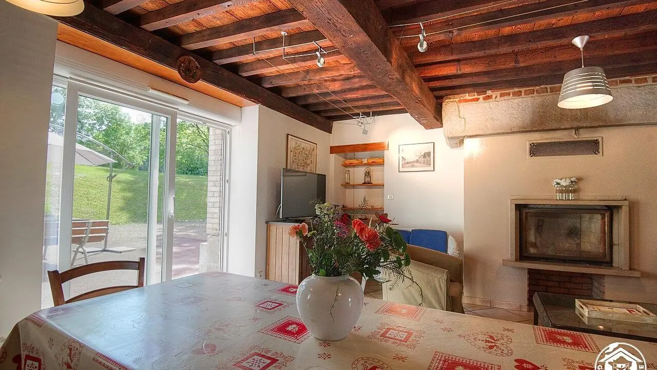 Vue sur le salon avec sa cheminée de la cuisine