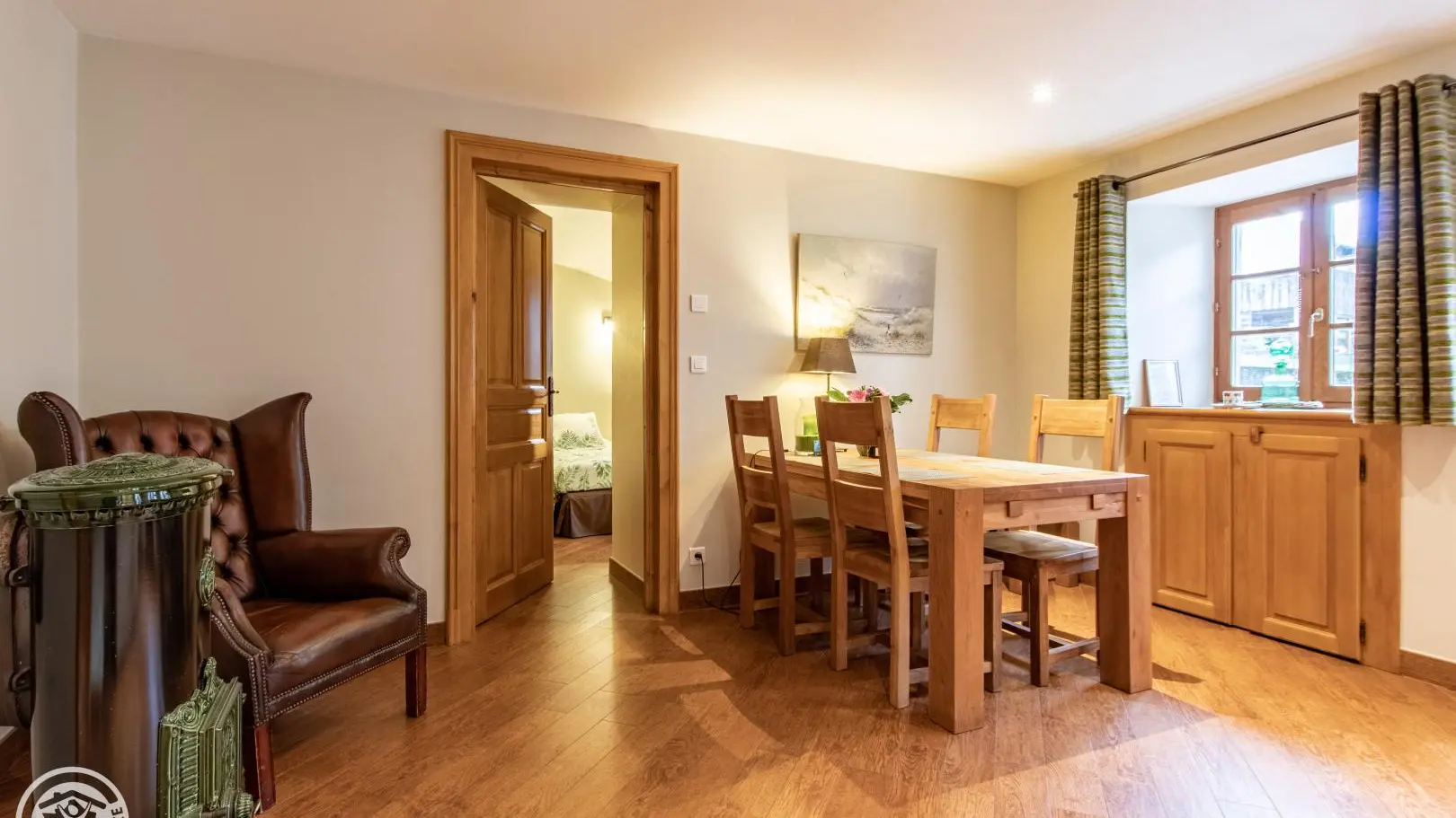 Espace repas avec poêle à bois et accès chambre 1