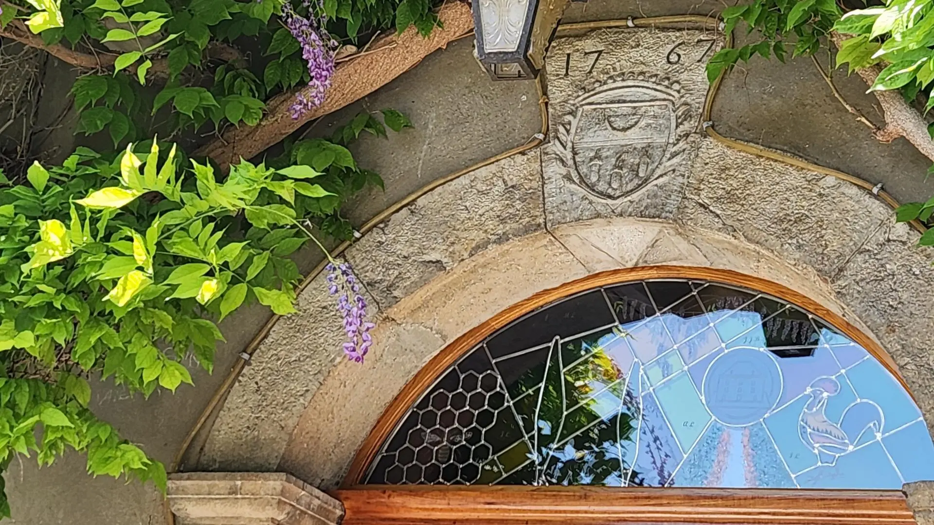 Clé de voute et vitrail au dessus de la porte d'entrée
