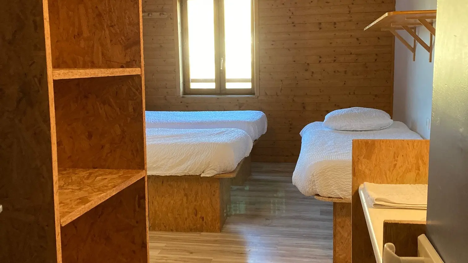 lits simples et rangement dans chambre privée pour 3 personnes