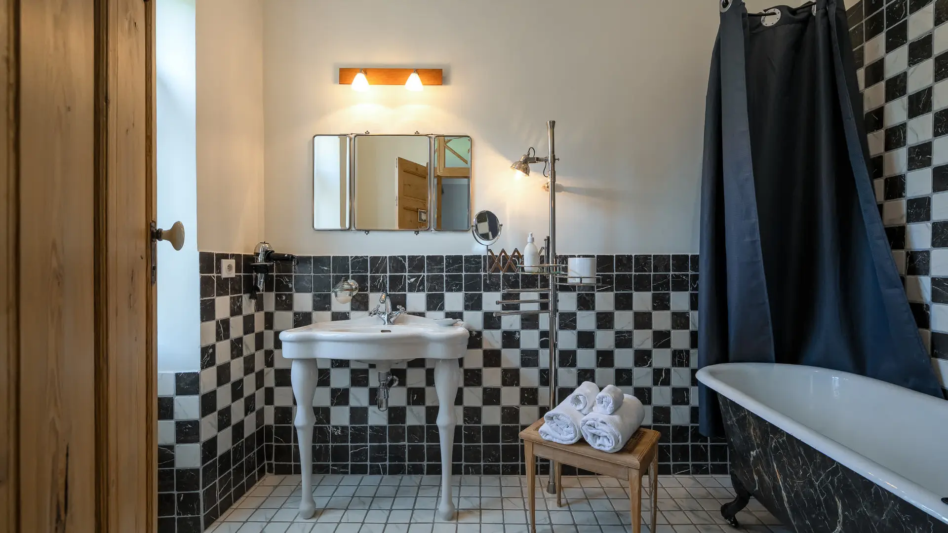 Salle de bain rétro, carreaux noir et blanc, baignoire sur pieds.