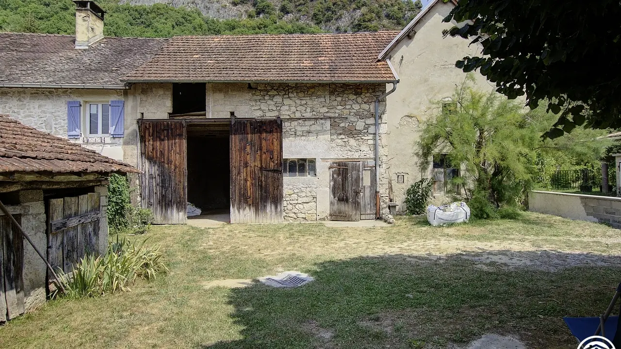 Au fond, en traversant la cour, le passage menant sur la grande terrasse couverte