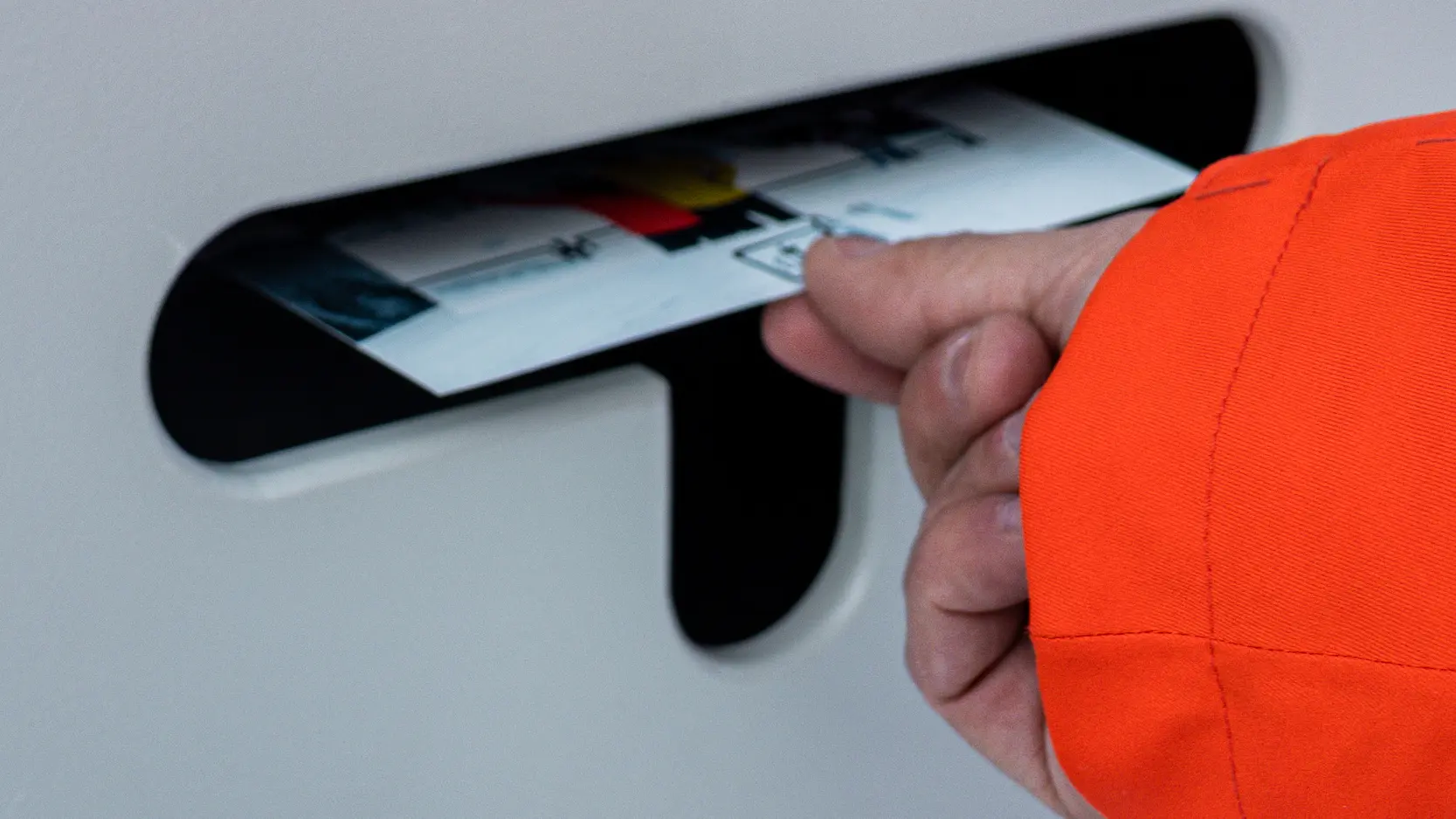 Une main sort une photo imprimée de la fente d'un photobooth