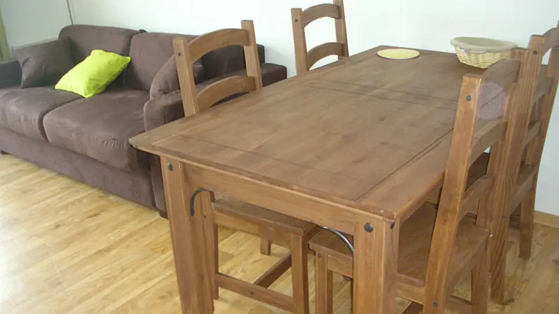Bright living room with sofa, dining table and parquet flooring