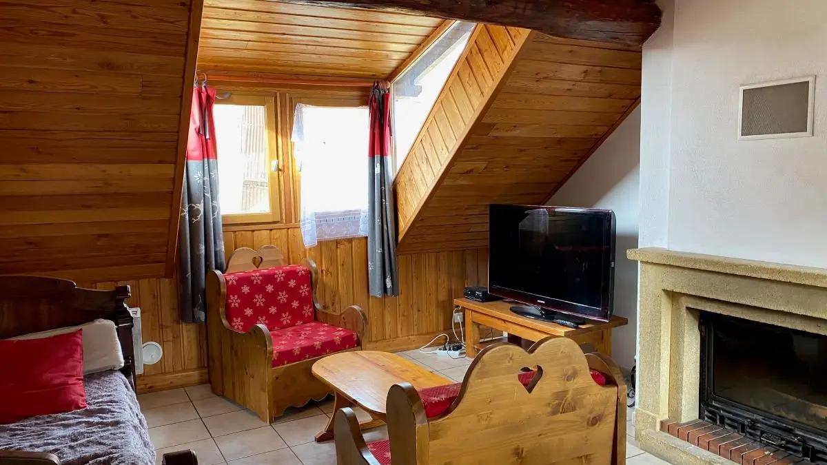 Comfortable, fully equipped living room with sofa, armchair, TV, fireplace, window