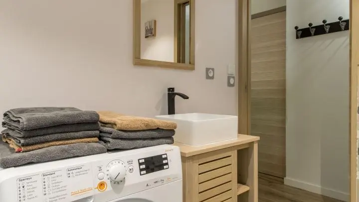 Salle d'eau avec lave-linge séchant