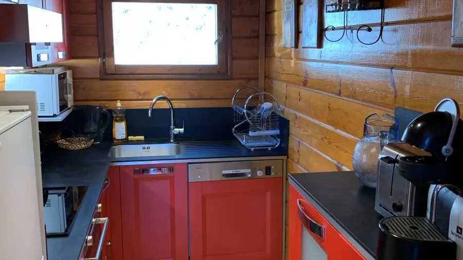 Modern and bright kitchenette with electric hob, wooden furniture, window