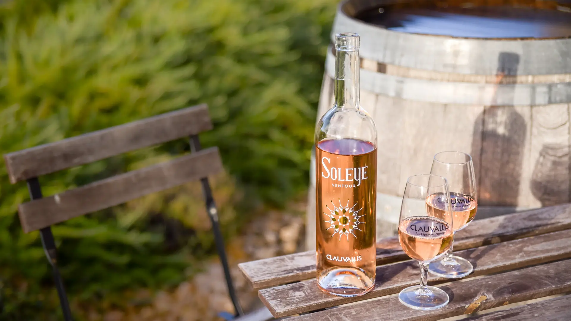 Bouteille de vin rosé Soleye Clauvallis et verres servis sur une table en terrasse, ambiance conviviale.