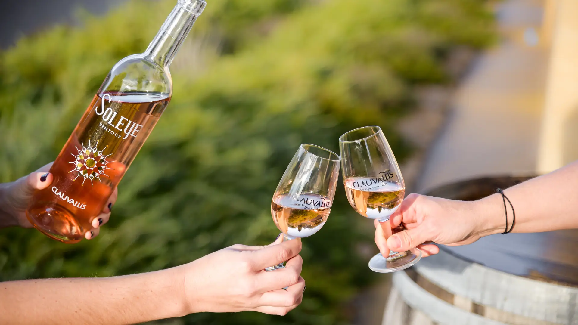 Dégustation de vin rosé Soleye Clauvallis en extérieur, verres qui trinquent au soleil.