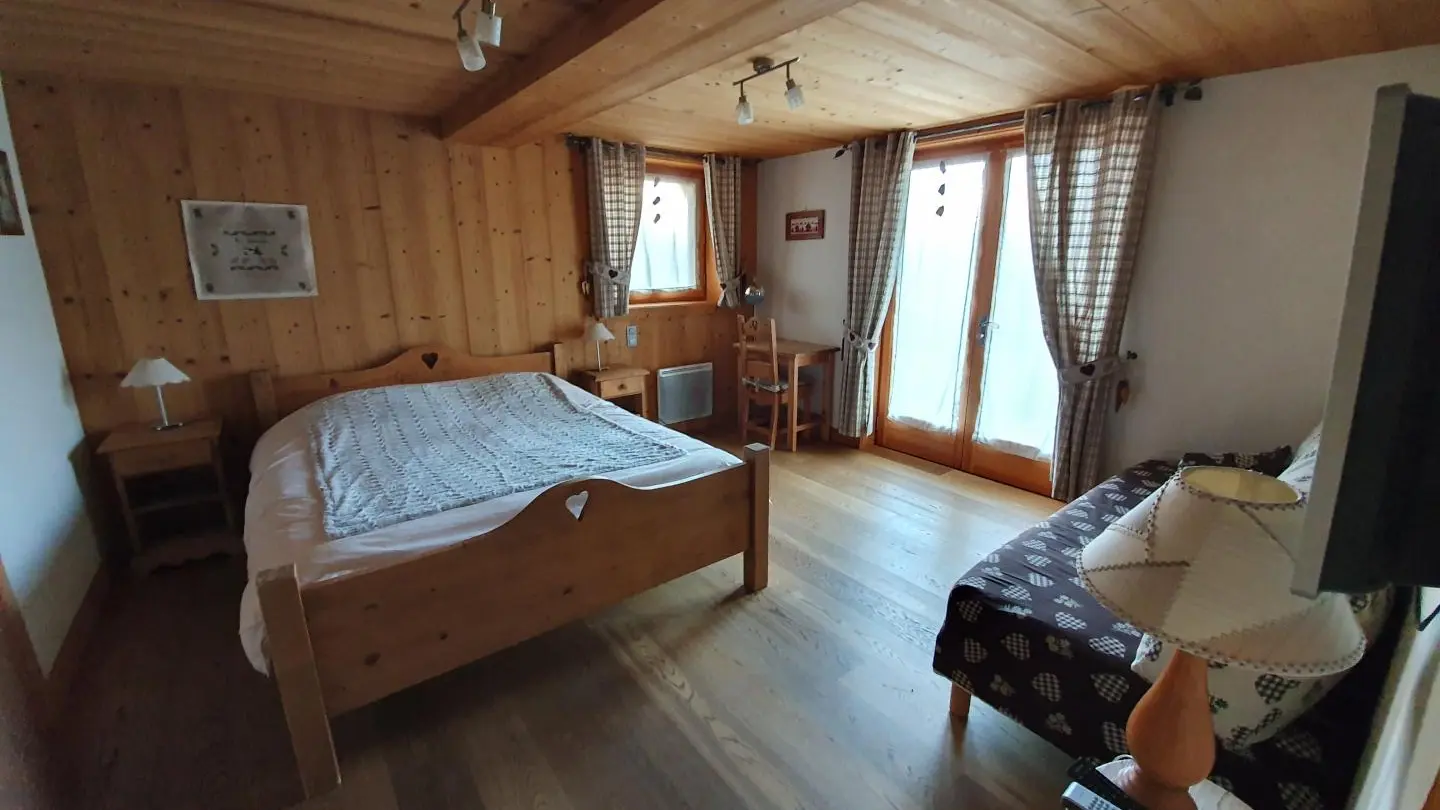 Chambre du rez de chaussée avec son accès direct à l'extérieur. Un lit 160x200 et un lit 90*200, téléviseur, dressing, salle de bain et toilettes attenants