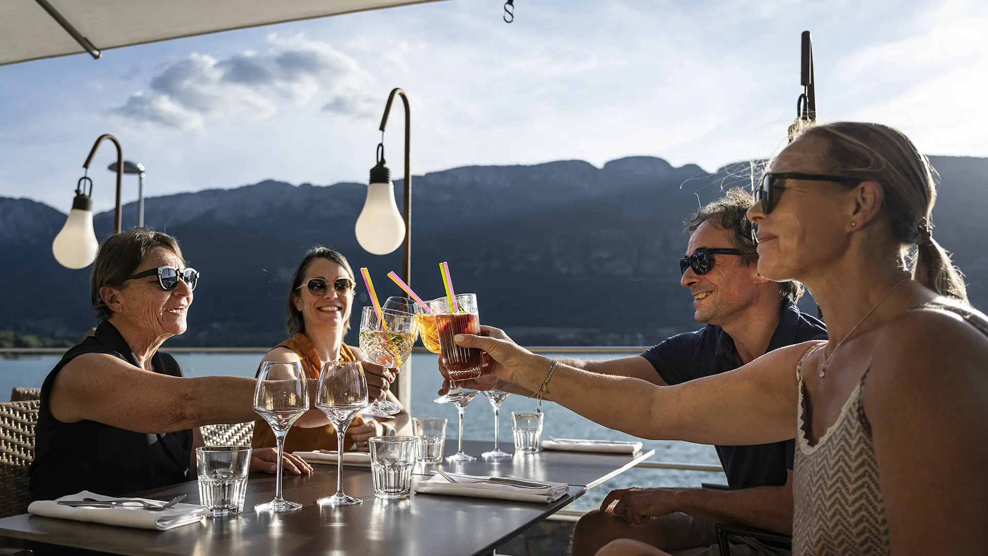 amis à l'apéritif sous parasol vue sur le lac d'annecy