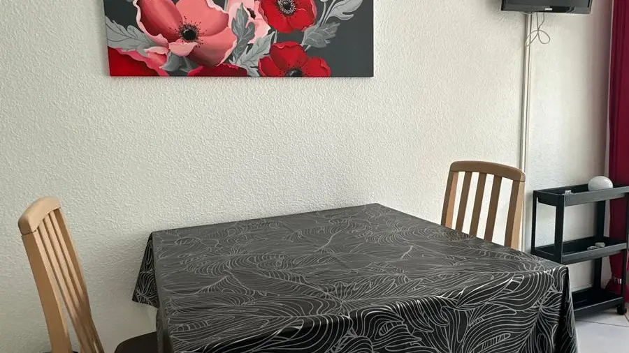 Le coin repas avec une table rectangulaire et deux chaises.