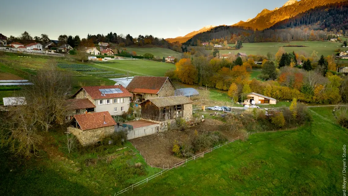 La ferme vue drone avec les montagnes en arrière plan.