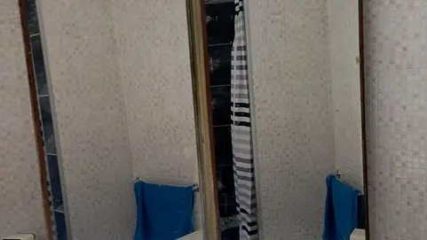 Salle de douche avec lavabo et grands miroirs