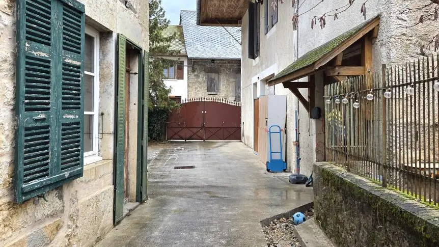 L'entrée se fait par le portail rouge, et le gîte se situe sur la droite avec les barrières.