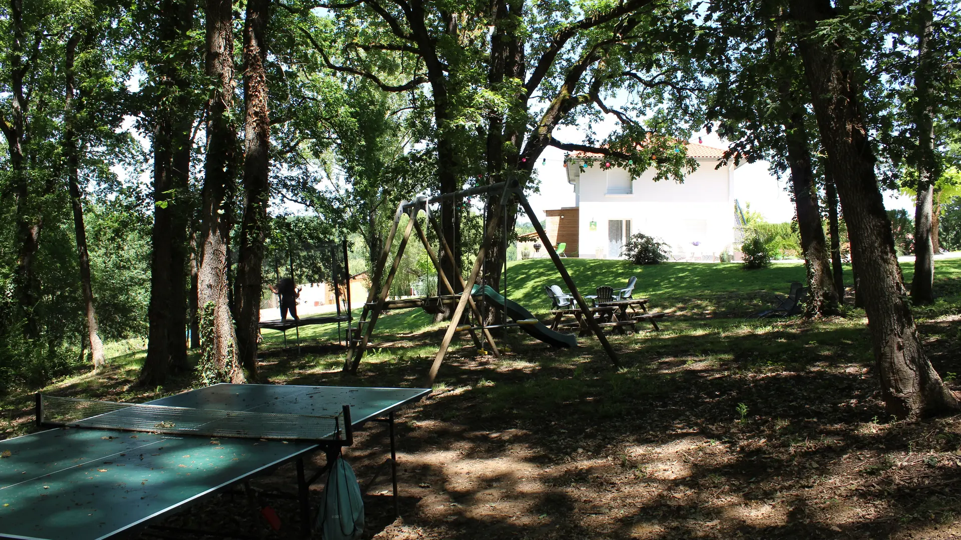 Coin jeux : balançoire, table ping-pong, trampoline, table pique-nique, coin détente