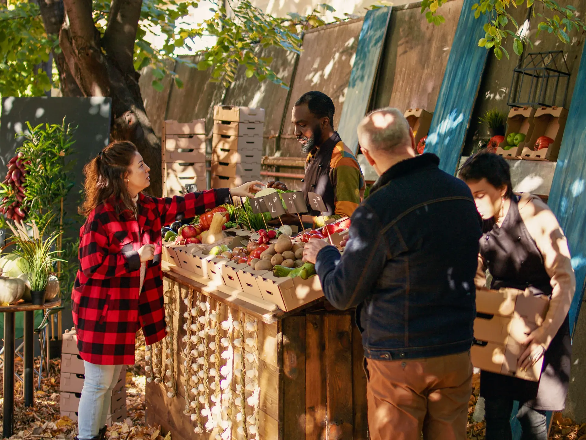 Young farmer serving client with various produce