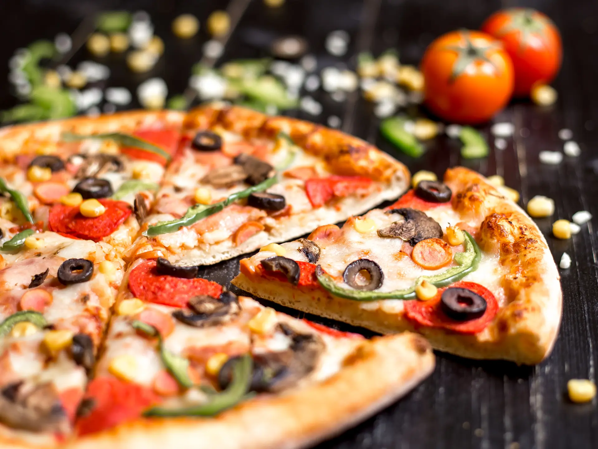 close up of pepperoni pizza slices with sausages mushroom olive bell pepper and cheese