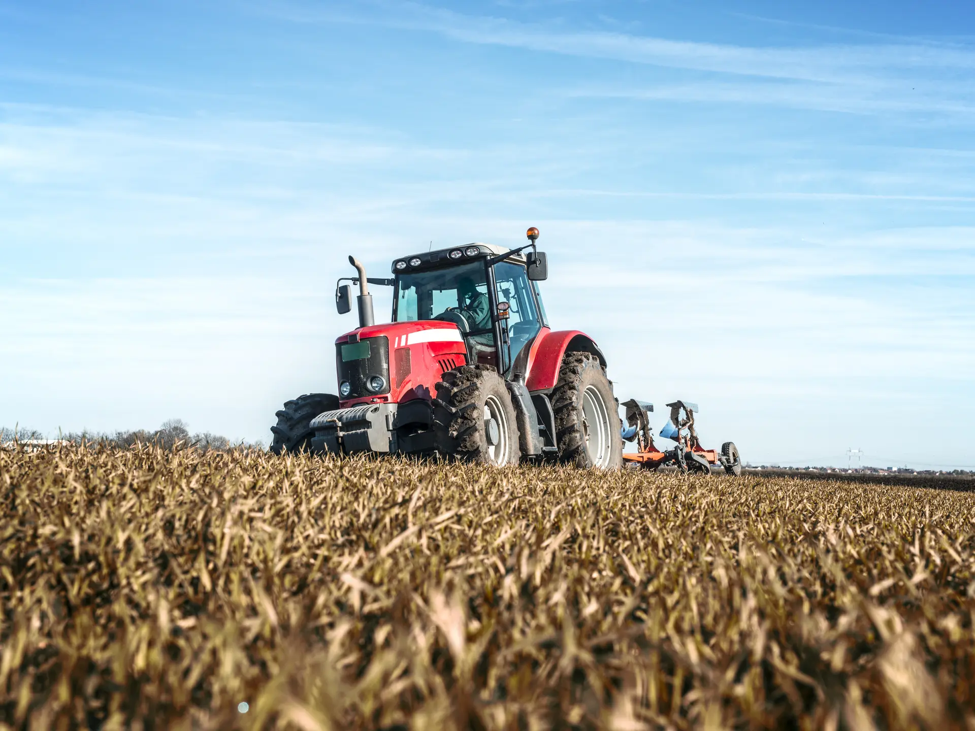 Tractor agricultural machine cultivating field.