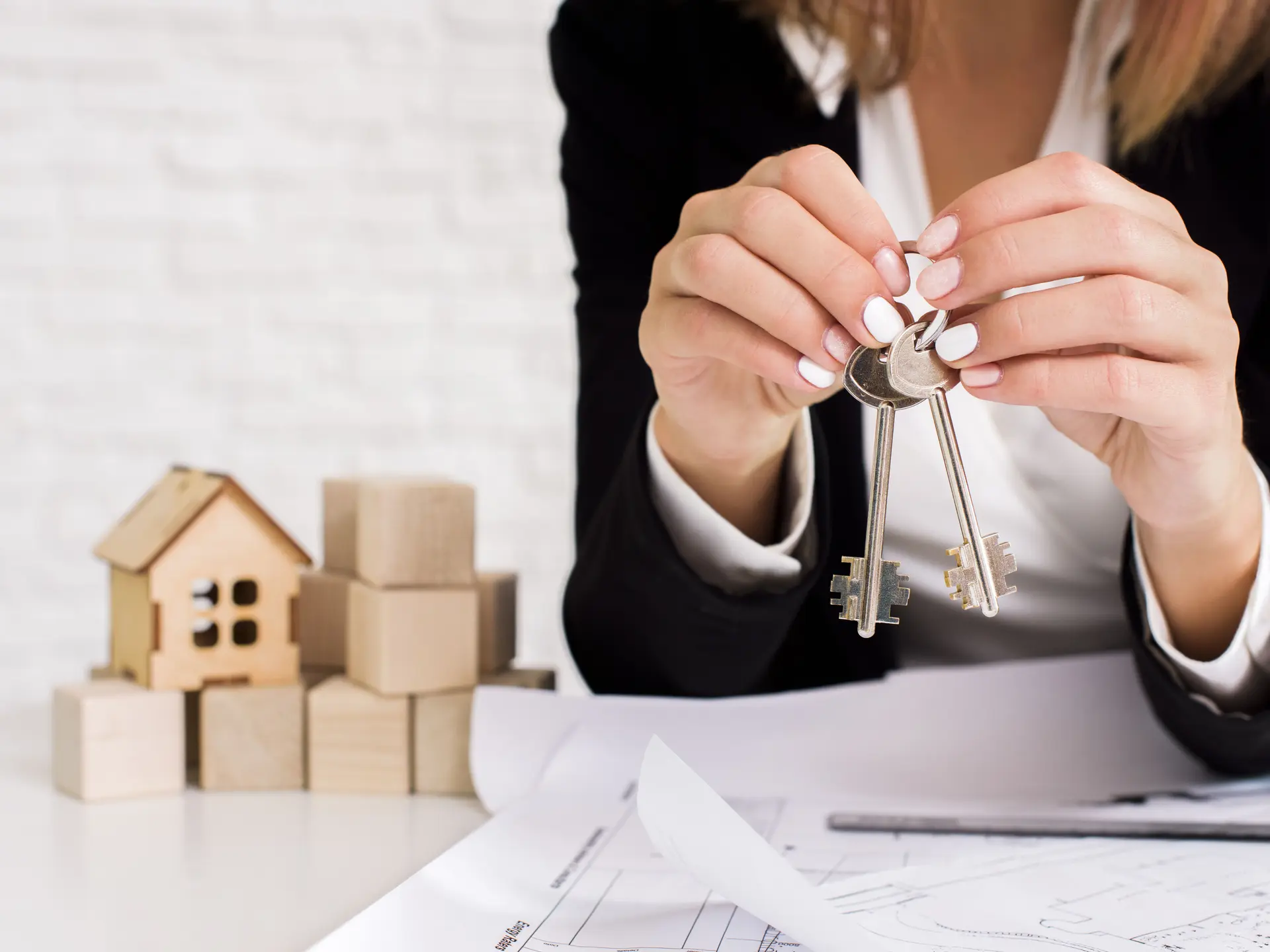 woman-holding-set-keys-with-wooden-cubes