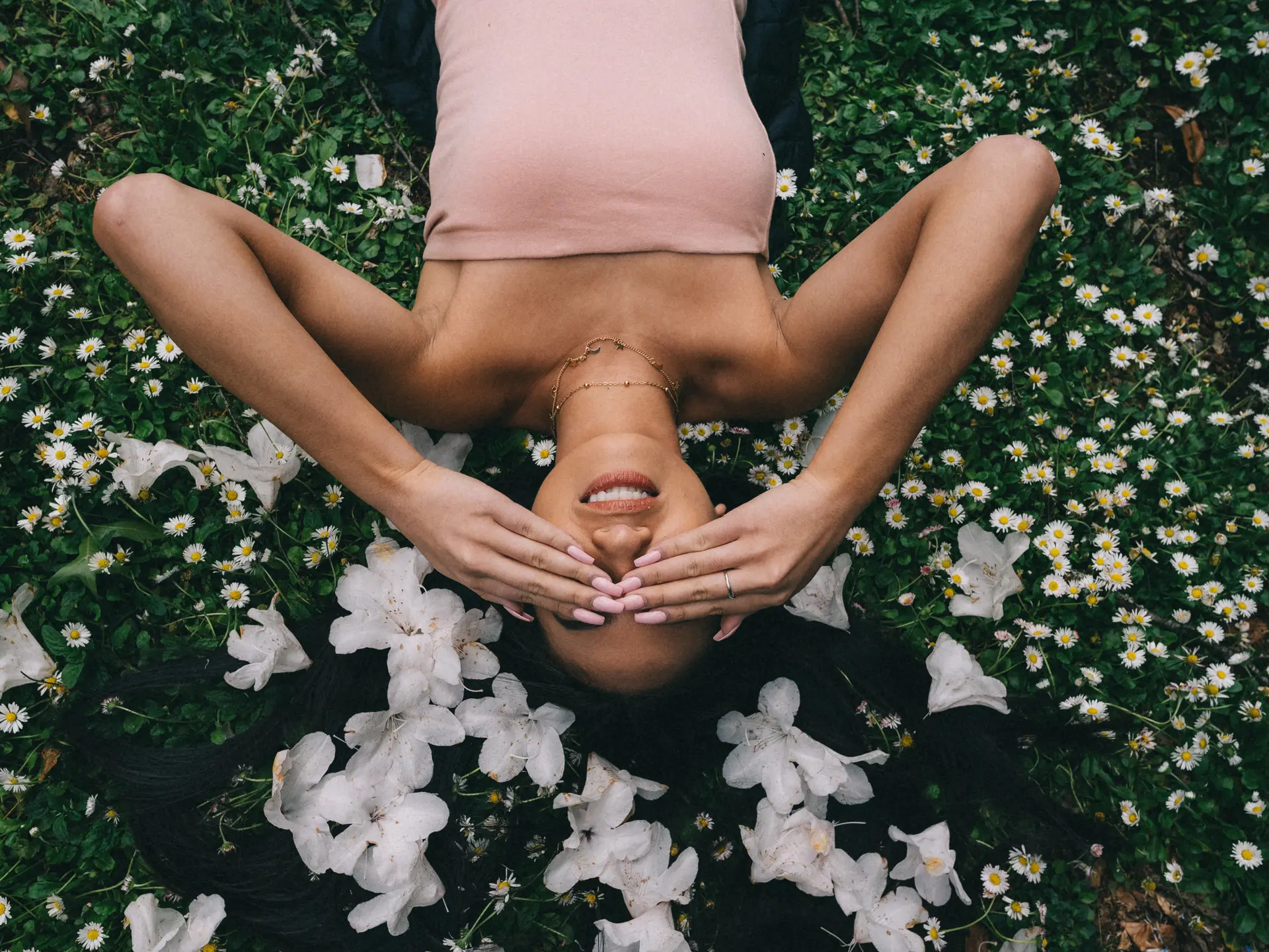 beautiful-model-laying-field-with-white-flowers