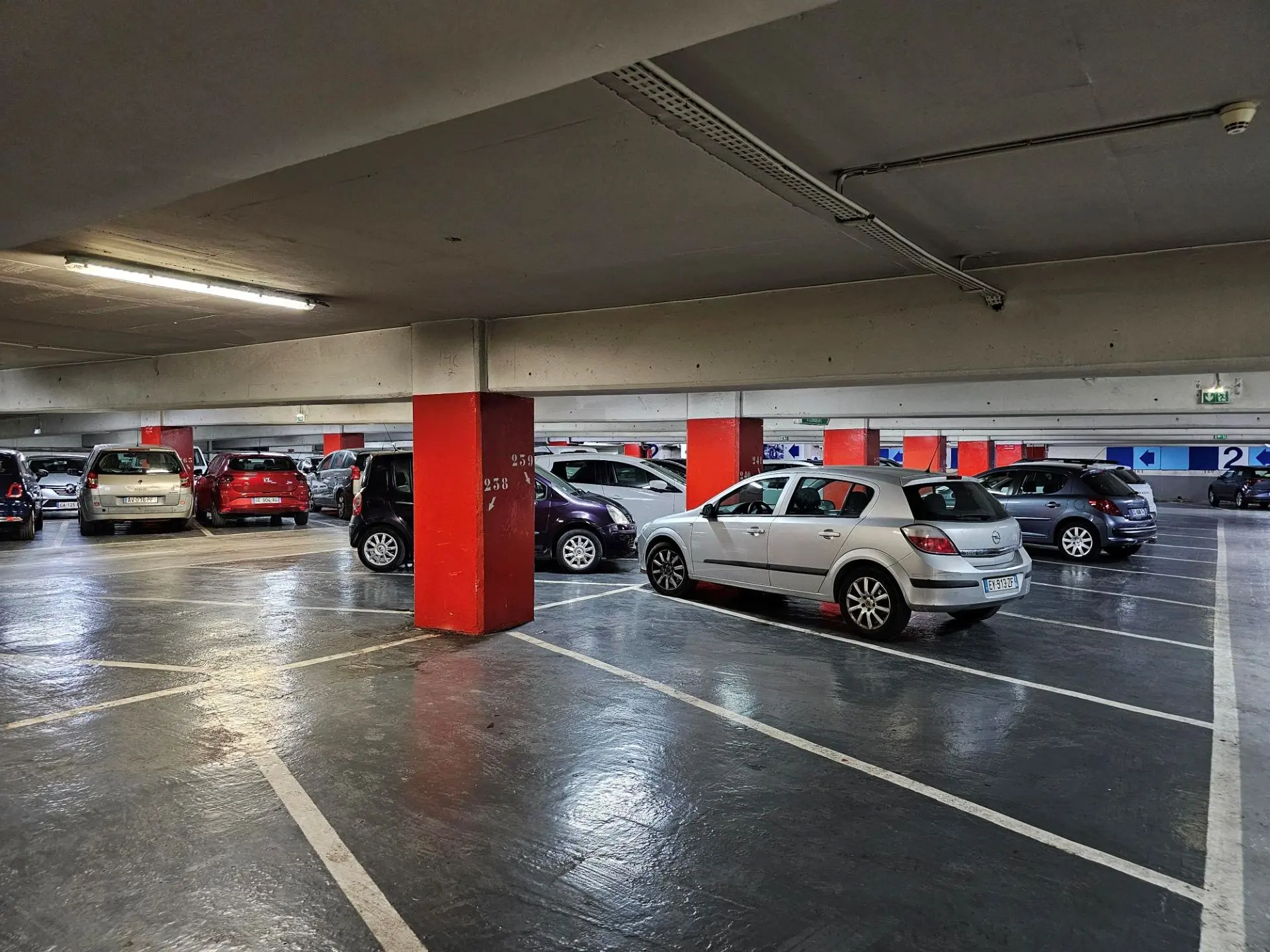 vue intérieur d'un étage du parking avec des véhicules stationnés