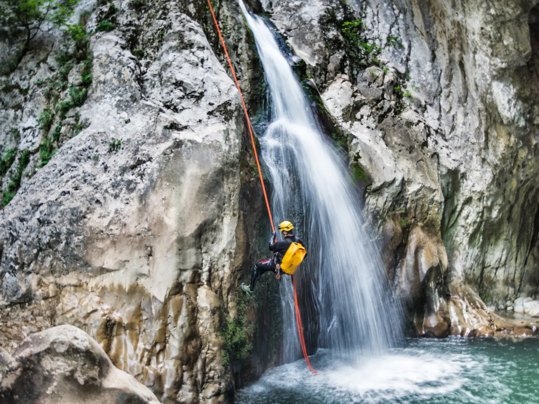 Persoon die een waterval afdaalt