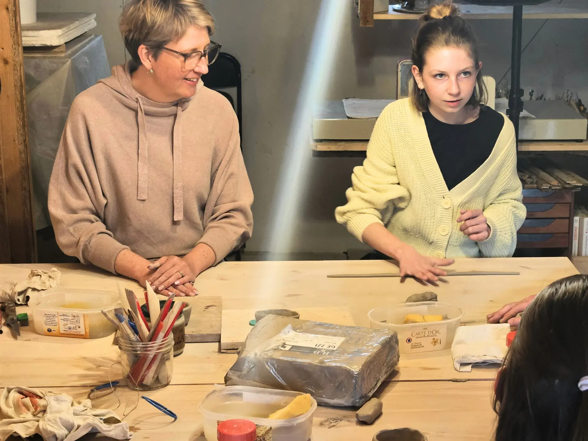 une femme et une jeune fille en atelier de poterie