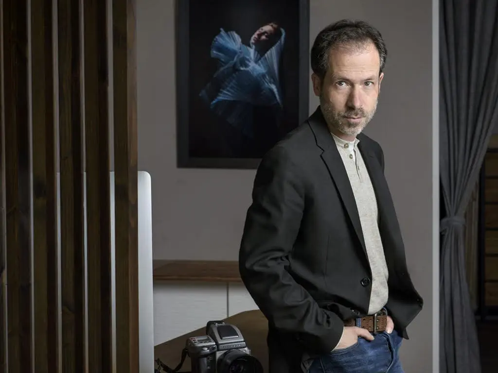 autoportrait du photographe adossé contre une table