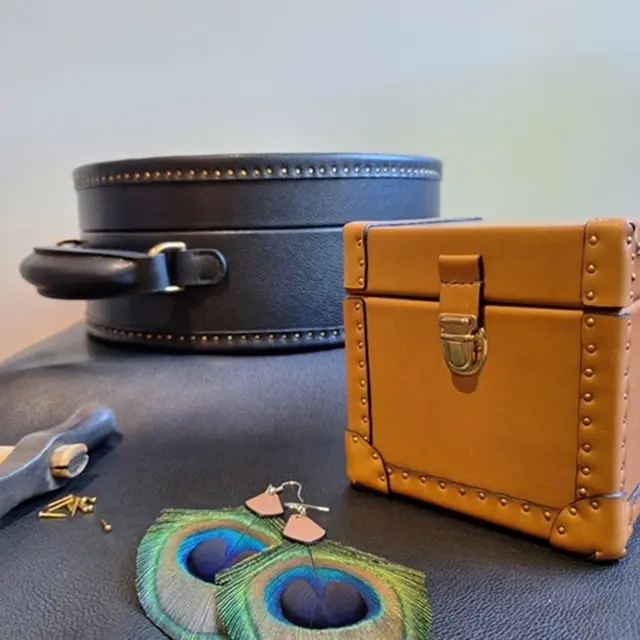 Malle et boite à bijoux avec boucles d'oreilles alliant cuir et plumes de paon