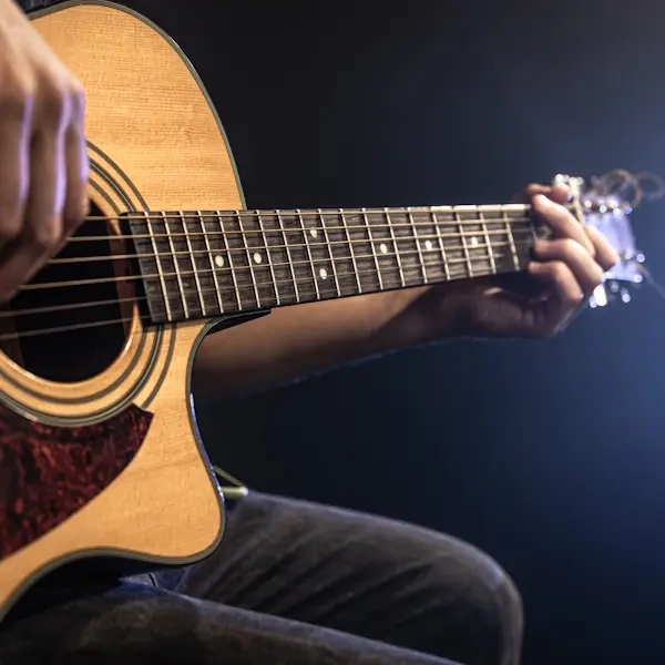 Close-up shot of guitarist playing acoustic guitar, copy space.