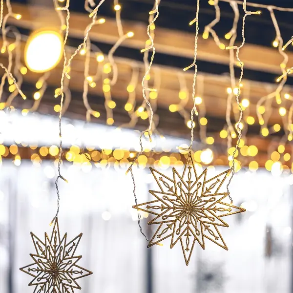 Decorative snowflakes and garlands on a blurred interior background.