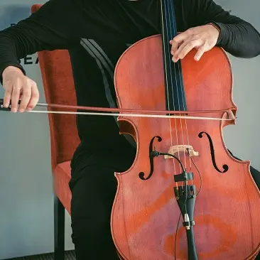 Man sitting on chair and plating cello