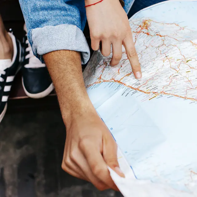 Hands of young couple on touristic map