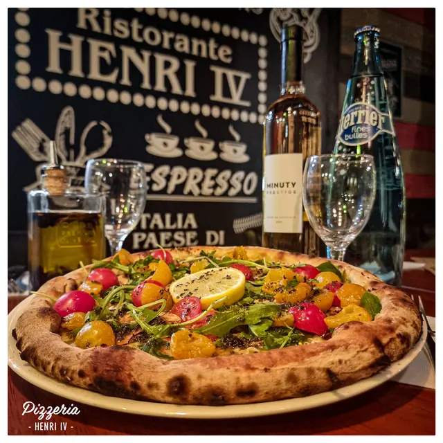 Pizzas fruits de mer avec un verre de vin blanc.