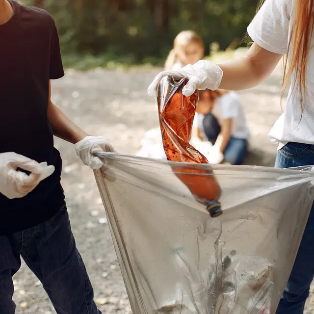 Children collects garbage in garbage bags in park