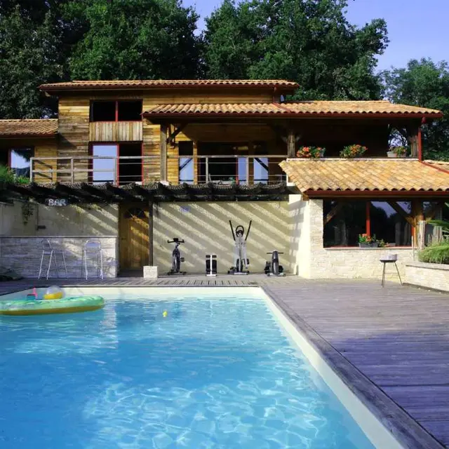 la piscine avec le gîte et la maison en arrière plan