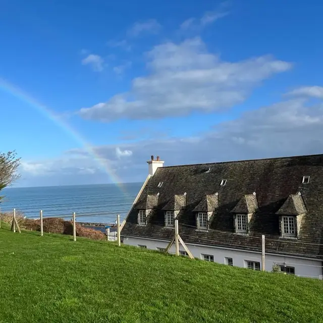 Maison vue arrière mer arc en ciel