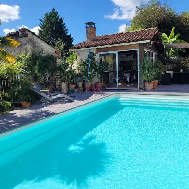 la piscine avec en fond la cuisine d'été du gite Pierre Forte