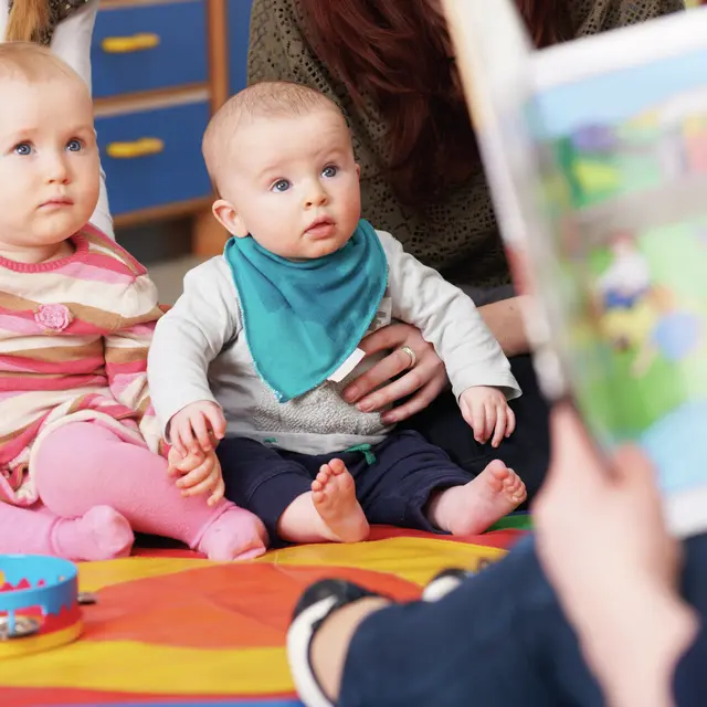 Mothers With Children At Baby Group Listening To Story