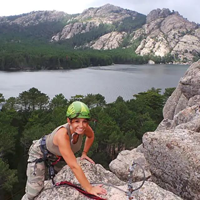 Femme qui finit sa session d'escalade,  le barrage et la forêt de l'Ospedale  en arrière plan