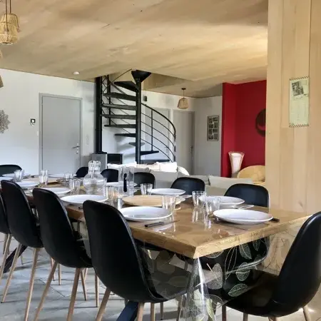 Le coin repas et la cuisine avec accès direct sur la terrasse couverte ; à gauche, l'entrée de la maison ;  près de l'escalier, le garage ;  au fond à droite, le salon, les toilettes, les 2 chambres du rez-de-chaussée et la salle de bain.