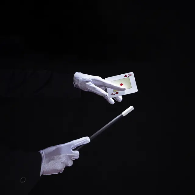 close-up-magician-performing-trick-playing-card-with-magic-wand.jpg