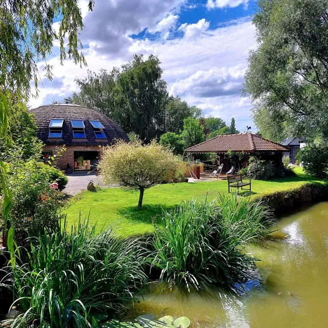 Maison dôme dans un parc arboré avec étang