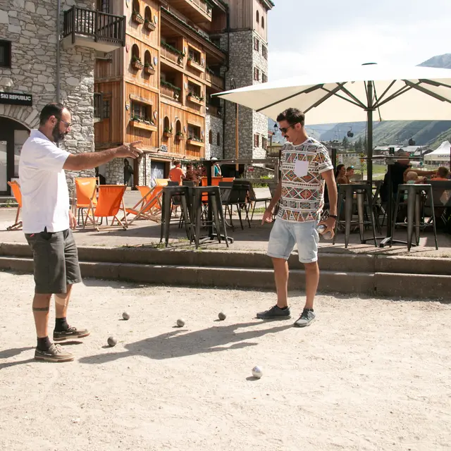 Deux amis qui jouent à la pétanque à Val d'Isère en été