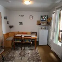 Séjour lumineux avec table à manger, tapis, canapé, banquette, TV, ameublement bois, fenêtre