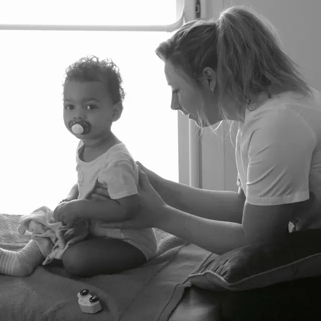 Photo en noir et blanc de Morgane exerçant auprès d'un enfant