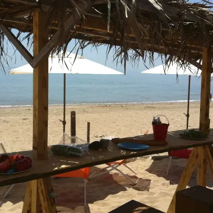Table ombragée les pieds dans le sable